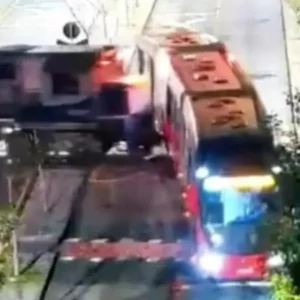 Trágico accidente: bus (estilo Transmilenio) se partió en dos luego de ser arrollado por un tren
