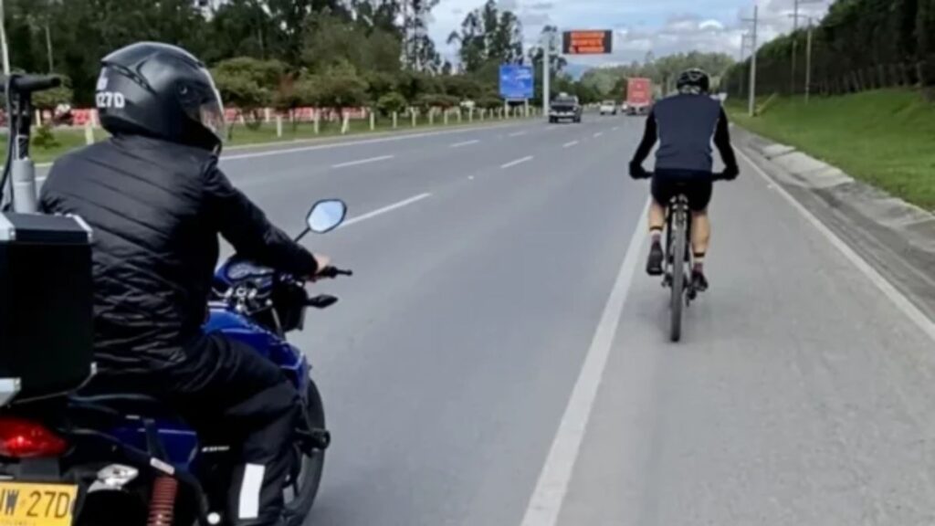 Motociclista y ciclista en carretera / Captura de pantalla página Two Bike